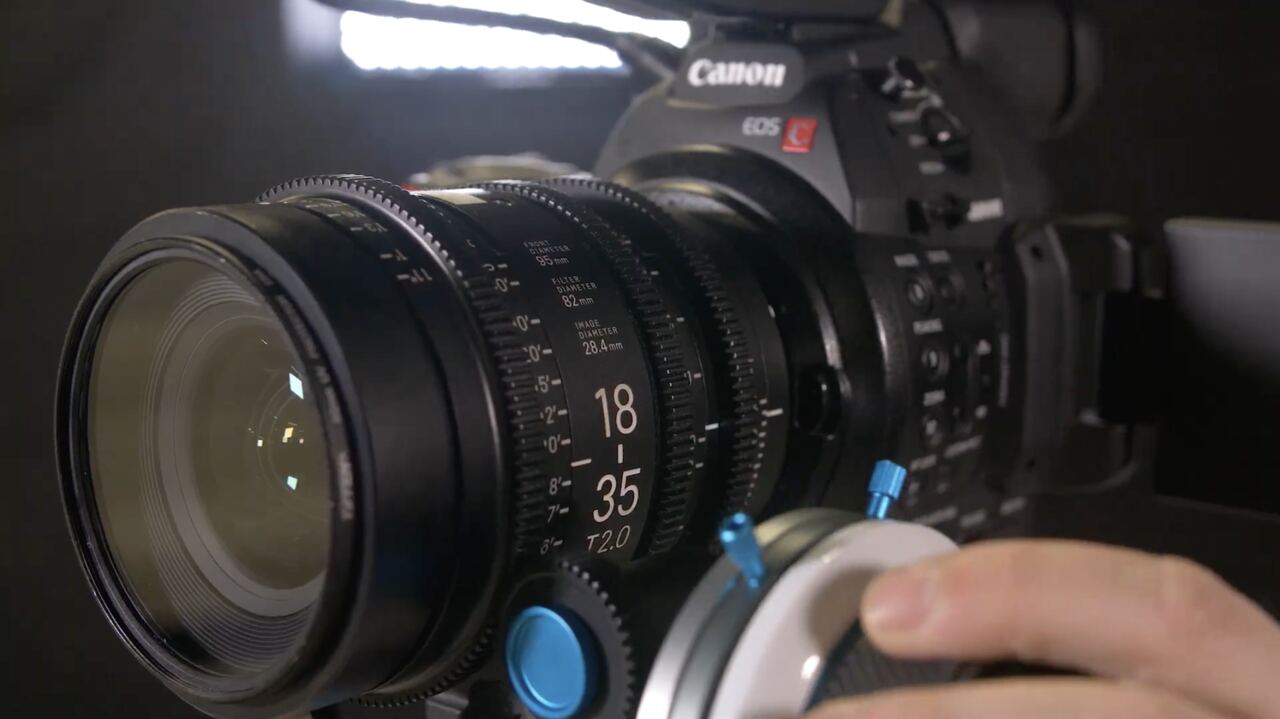 Gros plan sur l’objectif d’une caméra de cinéma Canon pendant la mise au point.